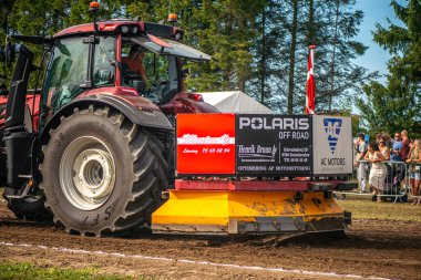 Aarhus, Danimarka. 16 Ağustos 2025 Güçlü makinelerin neşeli festival kalabalığından önce ağır topları çamura sürüklediği bir yarışma..