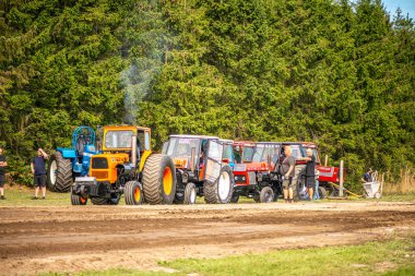 Aarhus, Danimarka. 16 Ağustos 2025 Güçlü makinelerin neşeli festival kalabalığından önce ağır topları çamura sürüklediği bir yarışma..