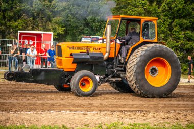 Aarhus, Danimarka. 16 Ağustos 2025 Güçlü makinelerin neşeli festival kalabalığından önce ağır topları çamura sürüklediği bir yarışma..