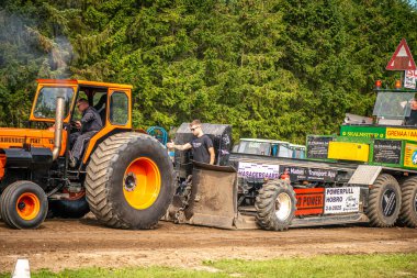 Aarhus, Danimarka. 16 Ağustos 2025 Güçlü makinelerin neşeli festival kalabalığından önce ağır topları çamura sürüklediği bir yarışma..