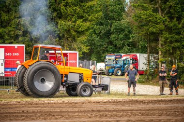 Aarhus, Danimarka. 16 Ağustos 2025 Güçlü makinelerin neşeli festival kalabalığından önce ağır topları çamura sürüklediği bir yarışma..
