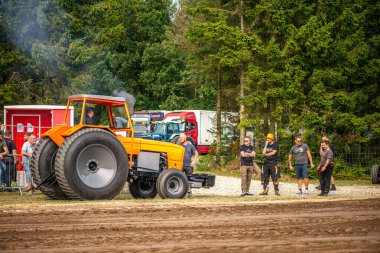 Aarhus, Danimarka. 16 Ağustos 2025 Güçlü makinelerin neşeli festival kalabalığından önce ağır topları çamura sürüklediği bir yarışma..