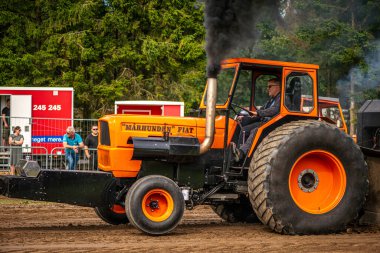 Aarhus, Danimarka. 16 Ağustos 2025 Güçlü makinelerin neşeli festival kalabalığından önce ağır topları çamura sürüklediği bir yarışma..