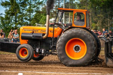 Aarhus, Danimarka. 16 Ağustos 2025 Güçlü makinelerin neşeli festival kalabalığından önce ağır topları çamura sürüklediği bir yarışma..