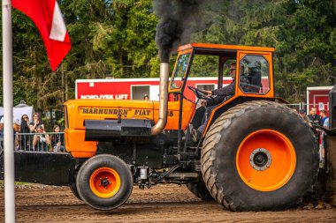 Aarhus, Danimarka. 16 Ağustos 2025 Güçlü makinelerin neşeli festival kalabalığından önce ağır topları çamura sürüklediği bir yarışma..