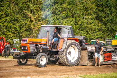 Aarhus, Danimarka. 16 Ağustos 2025 Güçlü makinelerin neşeli festival kalabalığından önce ağır topları çamura sürüklediği bir yarışma..