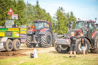 Aarhus, Danimarka. 16 Ağustos 2025 Güçlü makinelerin neşeli festival kalabalığından önce ağır topları çamura sürüklediği bir yarışma..