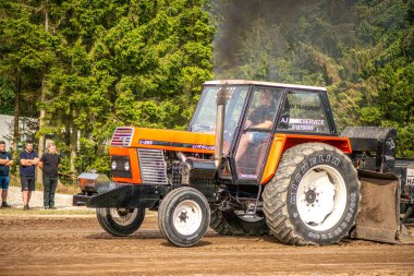 Aarhus, Danimarka. 16 Ağustos 2025 Güçlü makinelerin neşeli festival kalabalığından önce ağır topları çamura sürüklediği bir yarışma..