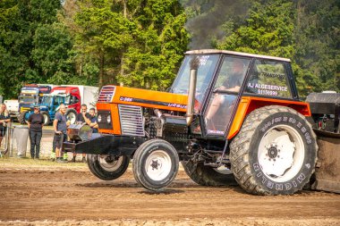 Aarhus, Danimarka. 16 Ağustos 2025 Güçlü makinelerin neşeli festival kalabalığından önce ağır topları çamura sürüklediği bir yarışma..