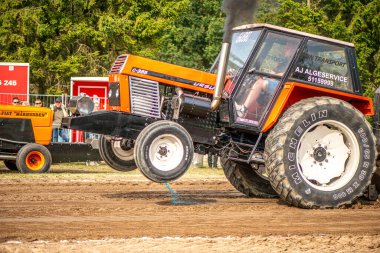 Aarhus, Danimarka. 16 Ağustos 2025 Güçlü makinelerin neşeli festival kalabalığından önce ağır topları çamura sürüklediği bir yarışma..