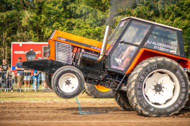 Aarhus, Danimarka. 16 Ağustos 2025 Güçlü makinelerin neşeli festival kalabalığından önce ağır topları çamura sürüklediği bir yarışma..