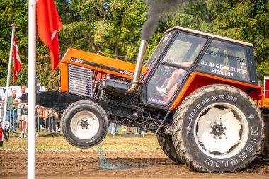 Aarhus, Danimarka. 16 Ağustos 2025 Güçlü makinelerin neşeli festival kalabalığından önce ağır topları çamura sürüklediği bir yarışma..
