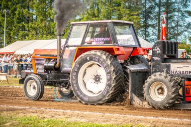 Aarhus, Danimarka. 16 Ağustos 2025 Güçlü makinelerin neşeli festival kalabalığından önce ağır topları çamura sürüklediği bir yarışma..
