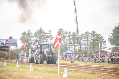 Aarhus, Danimarka. 16 Ağustos 2025 Güçlü makinelerin neşeli festival kalabalığından önce ağır topları çamura sürüklediği bir yarışma..