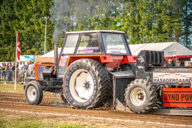 Aarhus, Danimarka. 16 Ağustos 2025 Güçlü makinelerin neşeli festival kalabalığından önce ağır topları çamura sürüklediği bir yarışma..
