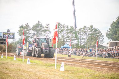 Aarhus, Danimarka. 16 Ağustos 2025 Güçlü makinelerin neşeli festival kalabalığından önce ağır topları çamura sürüklediği bir yarışma..