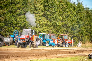 Aarhus, Danimarka. 16 Ağustos 2025 Güçlü makinelerin neşeli festival kalabalığından önce ağır topları çamura sürüklediği bir yarışma..