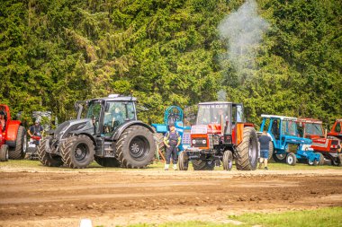Aarhus, Danimarka. 16 Ağustos 2025 Güçlü makinelerin neşeli festival kalabalığından önce ağır topları çamura sürüklediği bir yarışma..
