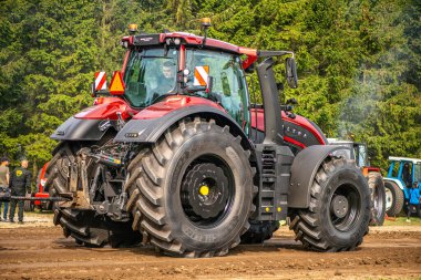Aarhus, Danimarka. 16 Ağustos 2025 Güçlü makinelerin neşeli festival kalabalığından önce ağır topları çamura sürüklediği bir yarışma..