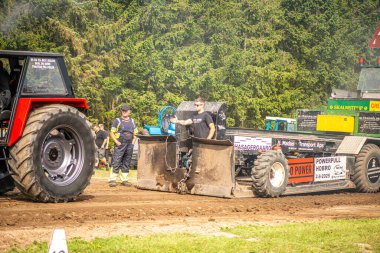 Aarhus, Danimarka. 16 Ağustos 2025 Güçlü makinelerin neşeli festival kalabalığından önce ağır topları çamura sürüklediği bir yarışma..