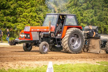 Aarhus, Danimarka. 16 Ağustos 2025 Güçlü makinelerin neşeli festival kalabalığından önce ağır topları çamura sürüklediği bir yarışma..