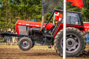 Aarhus, Danimarka. 16 Ağustos 2025 Güçlü makinelerin neşeli festival kalabalığından önce ağır topları çamura sürüklediği bir yarışma..