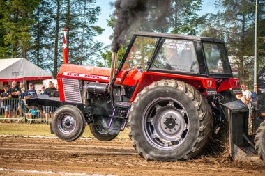 Aarhus, Danimarka. 16 Ağustos 2025 Güçlü makinelerin neşeli festival kalabalığından önce ağır topları çamura sürüklediği bir yarışma..