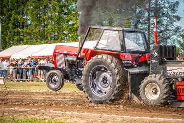 Aarhus, Danimarka. 16 Ağustos 2025 Güçlü makinelerin neşeli festival kalabalığından önce ağır topları çamura sürüklediği bir yarışma..