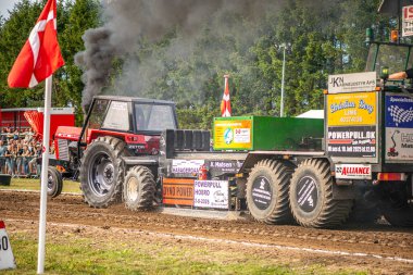 Aarhus, Danimarka. 16 Ağustos 2025 Güçlü makinelerin neşeli festival kalabalığından önce ağır topları çamura sürüklediği bir yarışma..