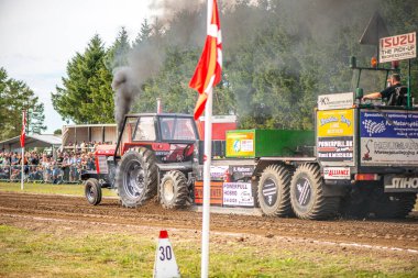 Aarhus, Danimarka. 16 Ağustos 2025 Güçlü makinelerin neşeli festival kalabalığından önce ağır topları çamura sürüklediği bir yarışma..