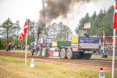 Aarhus, Danimarka. 16 Ağustos 2025 Güçlü makinelerin neşeli festival kalabalığından önce ağır topları çamura sürüklediği bir yarışma..