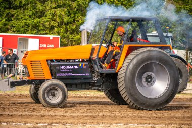 Aarhus, Danimarka. 16 Ağustos 2025 Güçlü makinelerin neşeli festival kalabalığından önce ağır topları çamura sürüklediği bir yarışma..