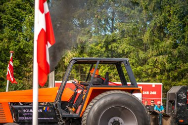 Aarhus, Danimarka. 16 Ağustos 2025 Güçlü makinelerin neşeli festival kalabalığından önce ağır topları çamura sürüklediği bir yarışma..