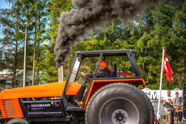 Aarhus, Danimarka. 16 Ağustos 2025 Güçlü makinelerin neşeli festival kalabalığından önce ağır topları çamura sürüklediği bir yarışma..