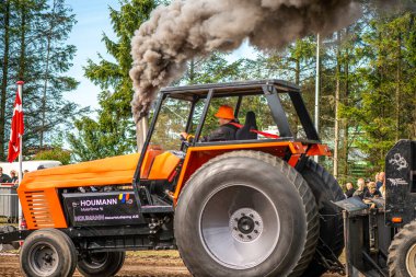 Aarhus, Danimarka. 16 Ağustos 2025 Güçlü makinelerin neşeli festival kalabalığından önce ağır topları çamura sürüklediği bir yarışma..