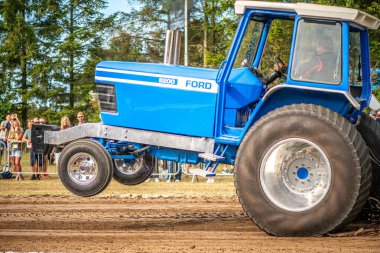 Aarhus, Danimarka. 16 Ağustos 2025 Güçlü makinelerin neşeli festival kalabalığından önce ağır topları çamura sürüklediği bir yarışma..