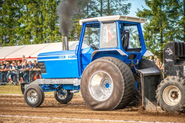 Aarhus, Danimarka. 16 Ağustos 2025 Güçlü makinelerin neşeli festival kalabalığından önce ağır topları çamura sürüklediği bir yarışma..