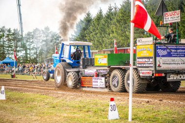 Aarhus, Danimarka. 16 Ağustos 2025 Güçlü makinelerin neşeli festival kalabalığından önce ağır topları çamura sürüklediği bir yarışma..