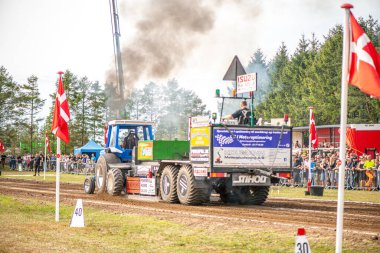 Aarhus, Danimarka. 16 Ağustos 2025 Güçlü makinelerin neşeli festival kalabalığından önce ağır topları çamura sürüklediği bir yarışma..