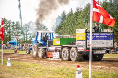 Aarhus, Danimarka. 16 Ağustos 2025 Güçlü makinelerin neşeli festival kalabalığından önce ağır topları çamura sürüklediği bir yarışma..