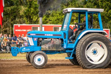 Aarhus, Danimarka. 16 Ağustos 2025 Güçlü makinelerin neşeli festival kalabalığından önce ağır topları çamura sürüklediği bir yarışma..