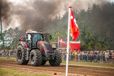 Aarhus, Danimarka. 16 Ağustos 2025 Güçlü makinelerin neşeli festival kalabalığından önce ağır topları çamura sürüklediği bir yarışma..