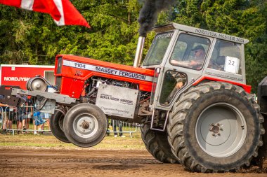 Aarhus, Danimarka. 16 Ağustos 2025 Güçlü makinelerin neşeli festival kalabalığından önce ağır topları çamura sürüklediği bir yarışma..
