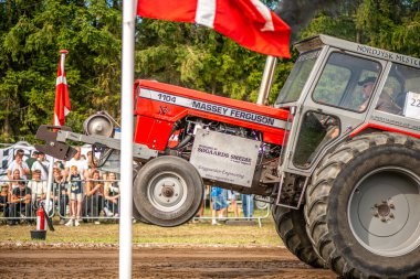 Aarhus, Danimarka. 16 Ağustos 2025 Güçlü makinelerin neşeli festival kalabalığından önce ağır topları çamura sürüklediği bir yarışma..
