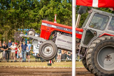 Aarhus, Danimarka. 16 Ağustos 2025 Güçlü makinelerin neşeli festival kalabalığından önce ağır topları çamura sürüklediği bir yarışma..