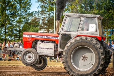 Aarhus, Danimarka. 16 Ağustos 2025 Güçlü makinelerin neşeli festival kalabalığından önce ağır topları çamura sürüklediği bir yarışma..