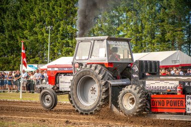 Aarhus, Danimarka. 16 Ağustos 2025 Güçlü makinelerin neşeli festival kalabalığından önce ağır topları çamura sürüklediği bir yarışma..
