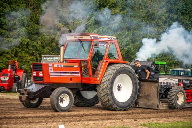 Aarhus, Danimarka. 16 Ağustos 2025 Güçlü makinelerin neşeli festival kalabalığından önce ağır topları çamura sürüklediği bir yarışma..