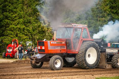 Aarhus, Danimarka. 16 Ağustos 2025 Güçlü makinelerin neşeli festival kalabalığından önce ağır topları çamura sürüklediği bir yarışma..