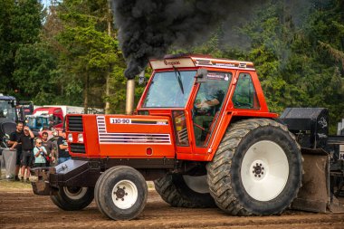 Aarhus, Danimarka. 16 Ağustos 2025 Güçlü makinelerin neşeli festival kalabalığından önce ağır topları çamura sürüklediği bir yarışma..